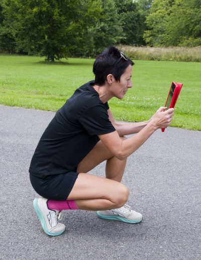 Lis weeks using a tablet to perform a running gait analysis in Mote Park for a runner